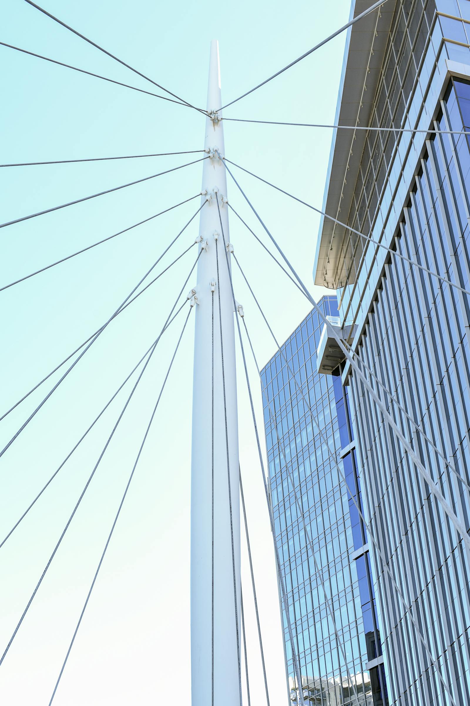 Steel beam with tensioned cables supporting a glass building facade