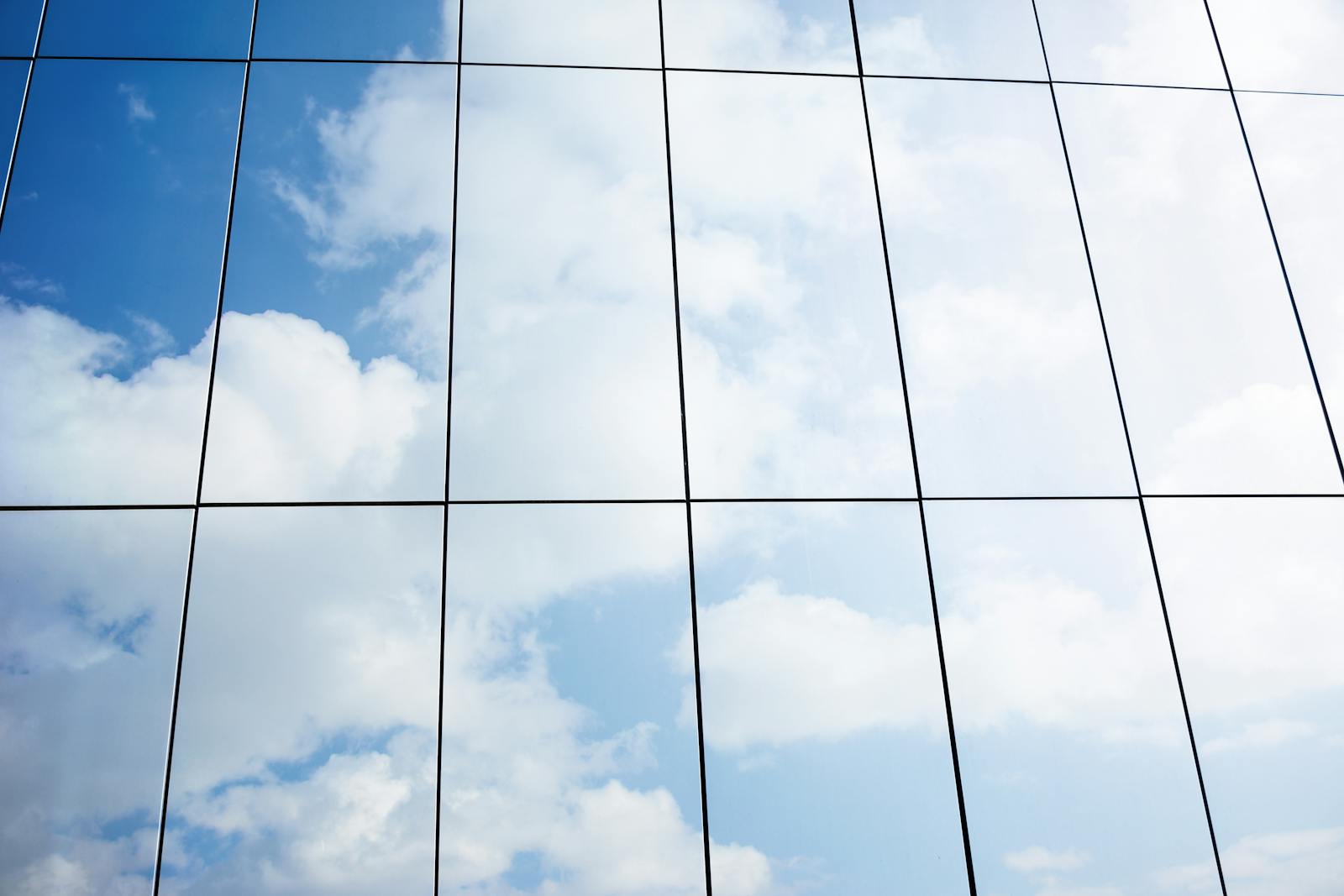 Reflection of clouds in modern glass building facade