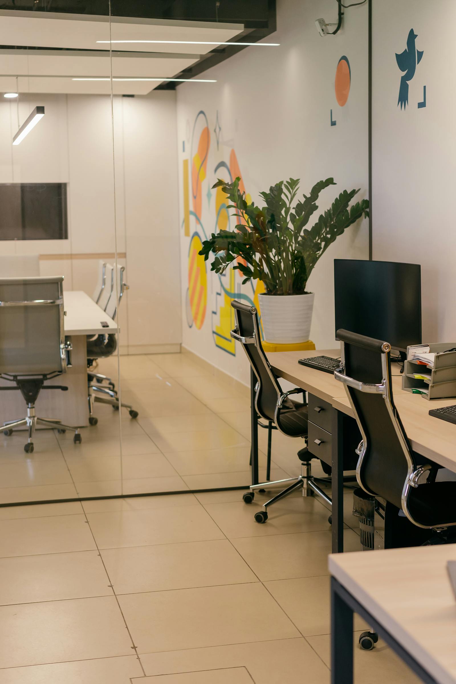Spacious office interior with glass partitions and vibrant wall art