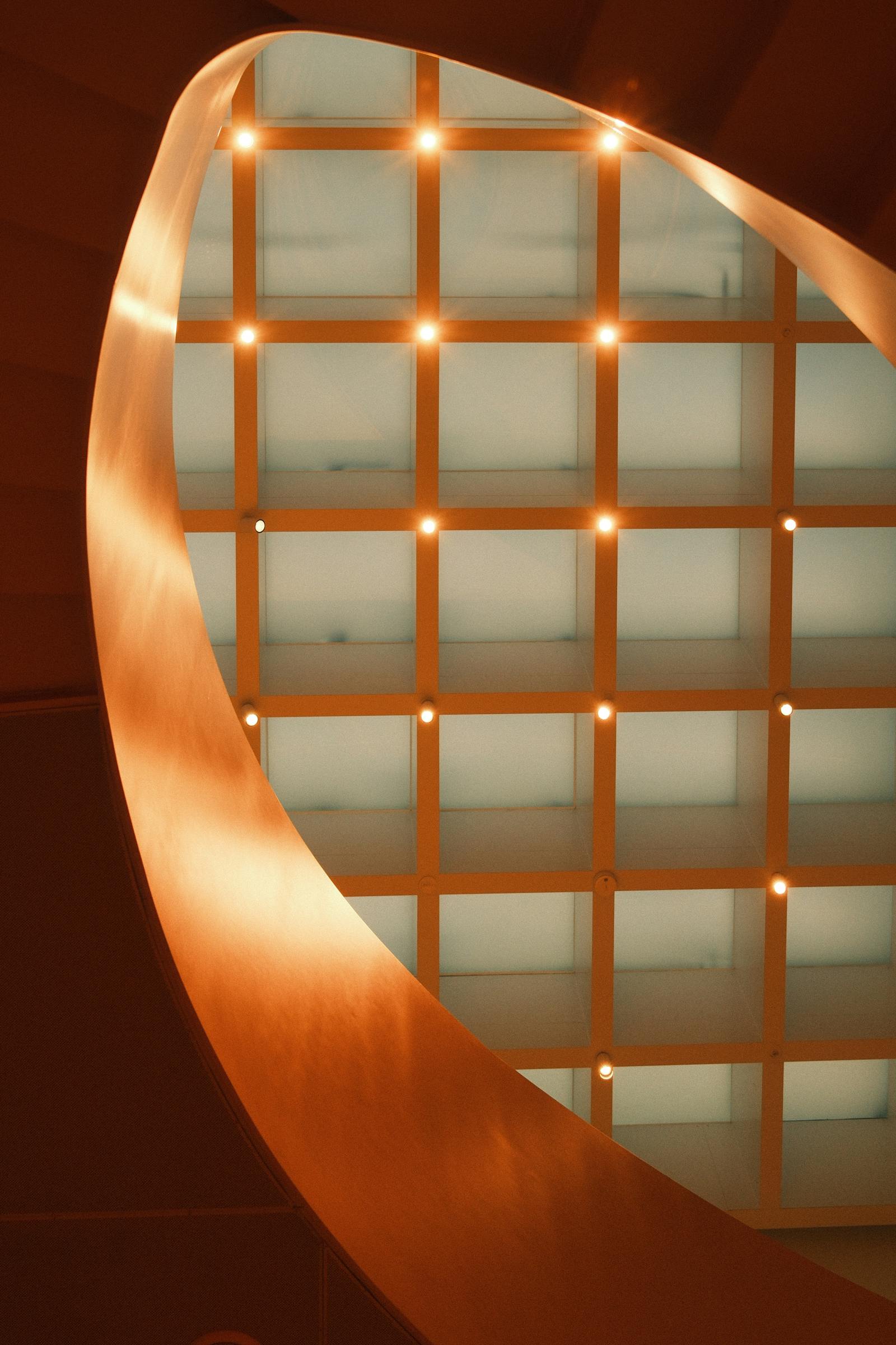 Curved architectural interior with warm accent lighting against a grid ceiling