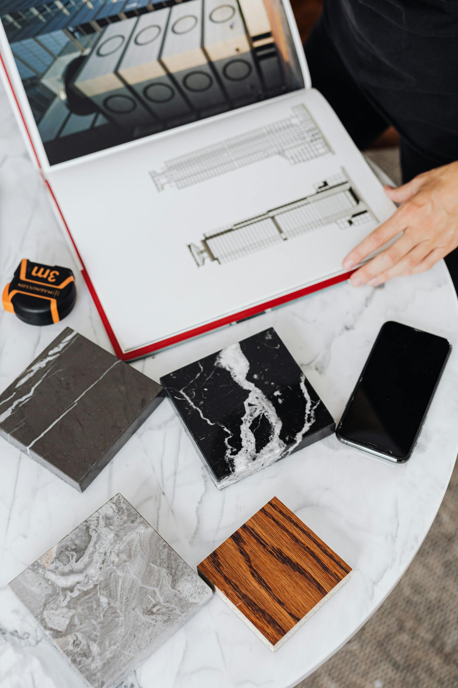 Architectural floor plans and tile samples laid out on a design table